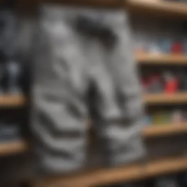 Various brands of gray cargo pants displayed on a shelf