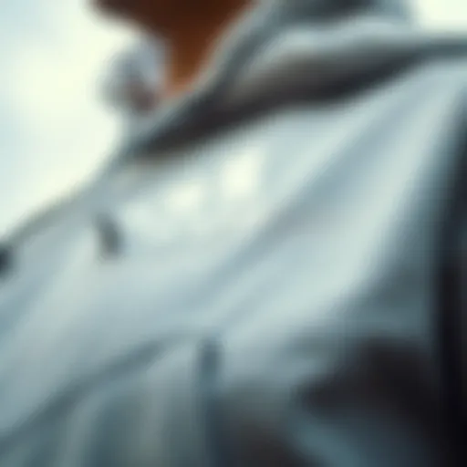 A close-up of a thin grey hoodie showcasing its fabric texture and design details.